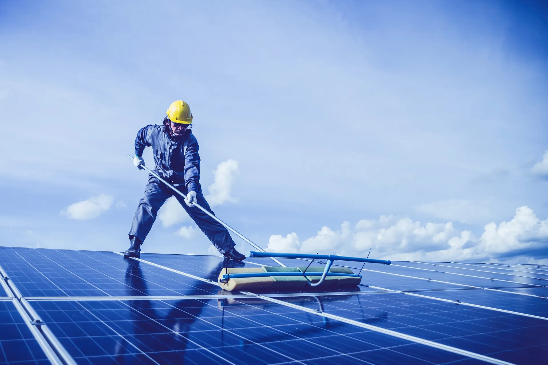 Maintenance technician cleaning a rooftop solar array